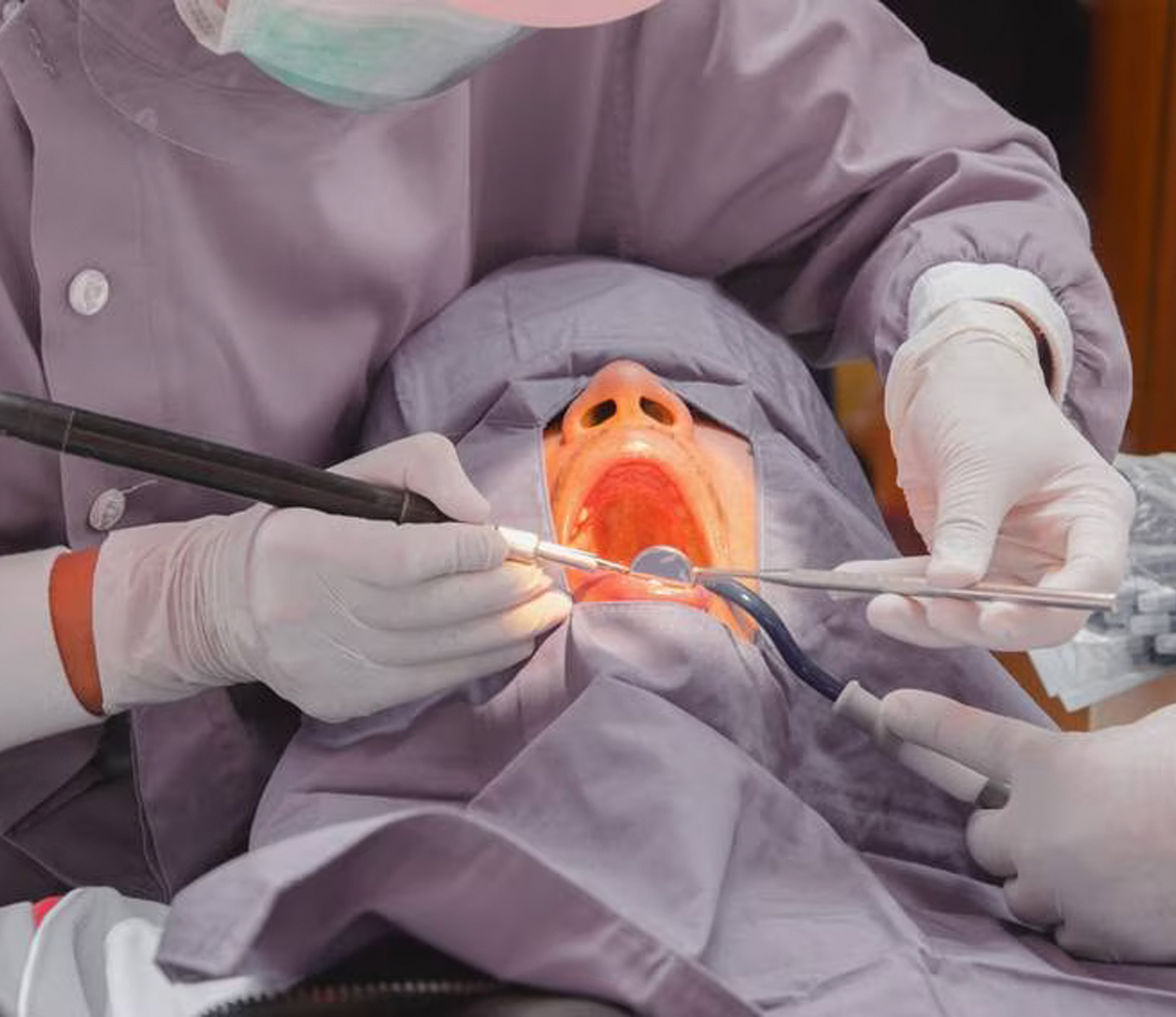 Dentist conducting a procedure on a patient's mouth.