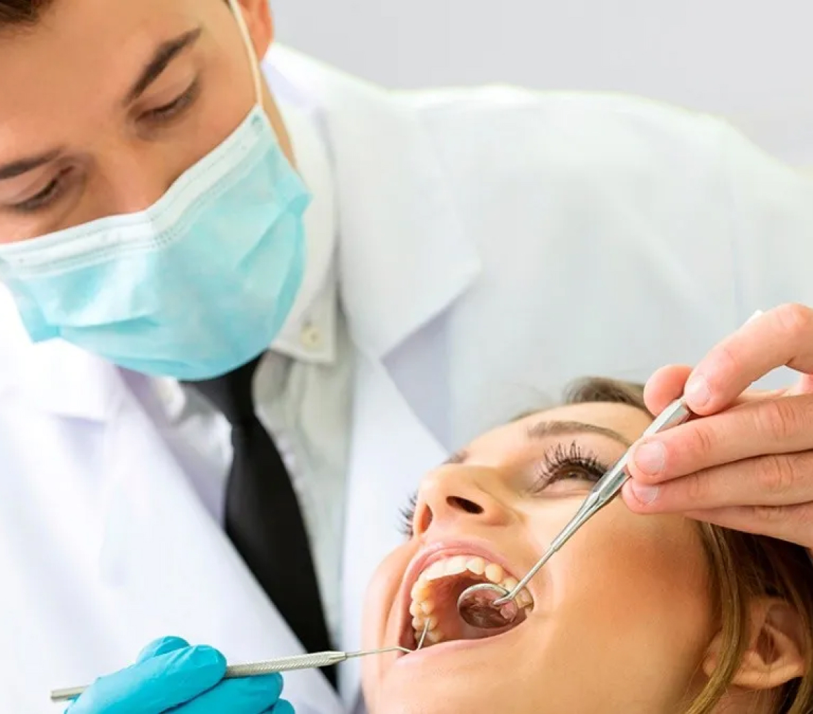 Dentist wearing a facemask working on a patient.